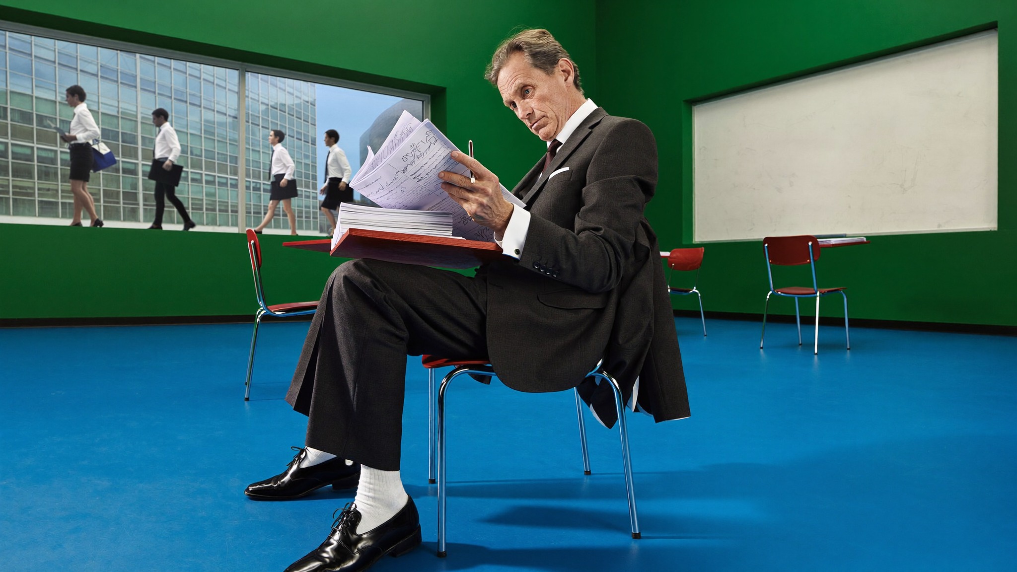 Executive reading a printout in a green and blue room